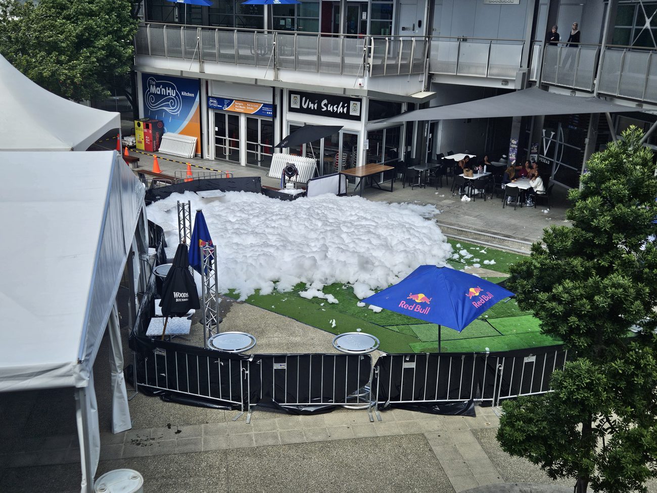 Kids charging through a wave of foam at a sunny school gala